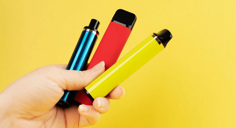Hand holding three vape devices